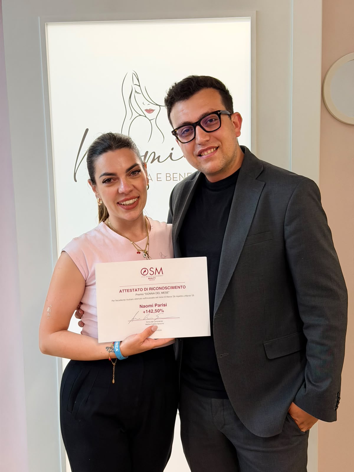 Mattia Cosimo Saracino con una cliente e l'attestato OSM Beauty, risultato +142,50%